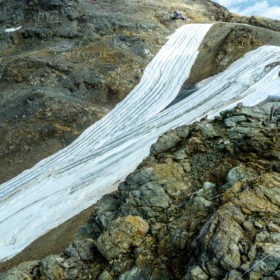 Die Verflüssigung des Wasserhaushalts betrifft auch die Tourismuswirtschaft. Mit Vliesabdeckungen versucht man auf der Diavolezza (Graubünden), das Abschmelzen der letzten Reste eines Gletschers zu stoppen und so einen frühen vorwinterlichen Saisonstart beim Skifahren zu ermöglichen. Foto: © Rolf Weingartner